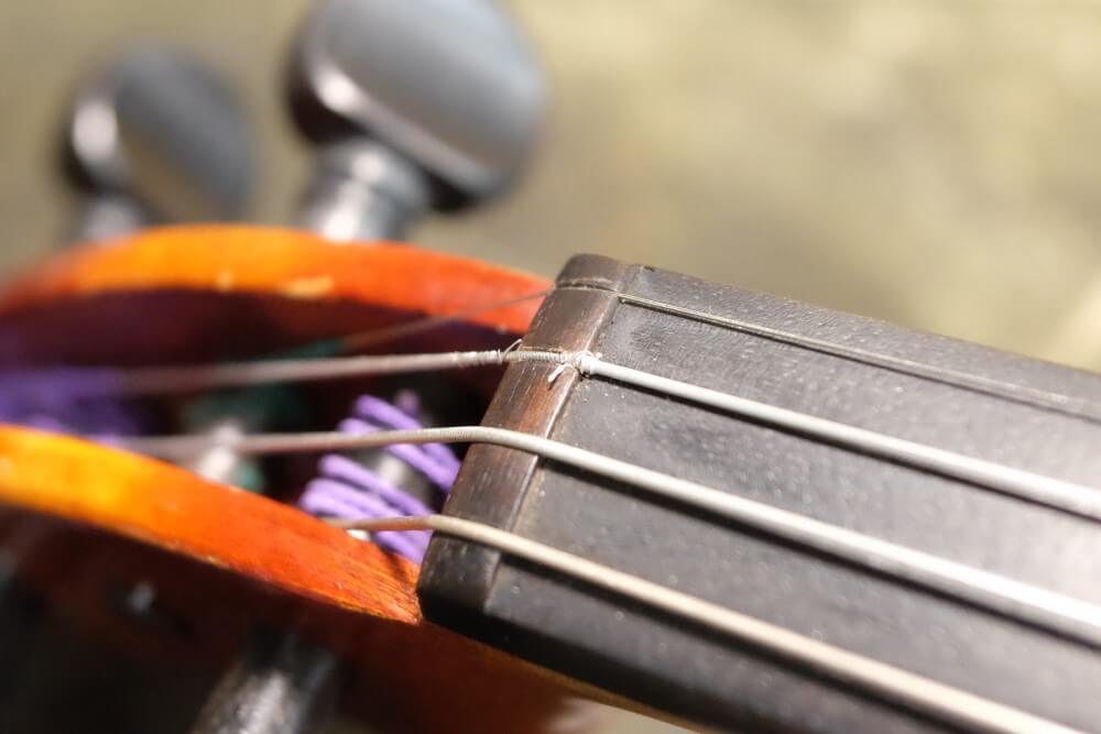 バイオリンのナットの上で弦がほつれている様子