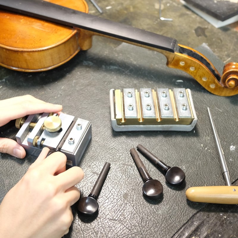交換のため形を整えられるバイオリンのペグ